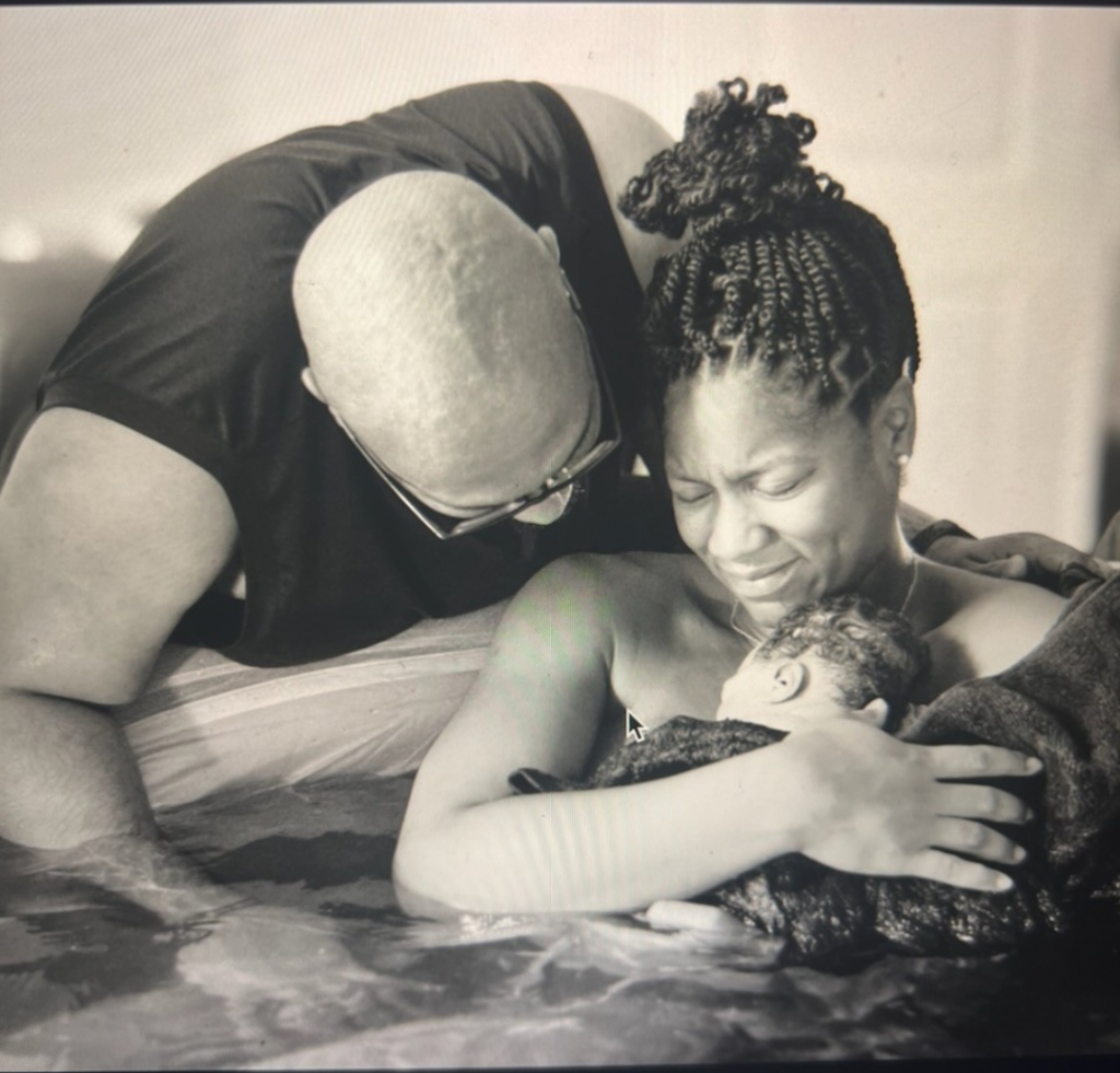 Husband holding and supporting his wife during labor, offering comfort and emotional strength in a calm environment birth center Durham NC